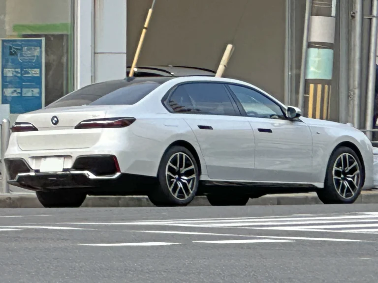 White BMW 740i sedan, rear three-quarter view