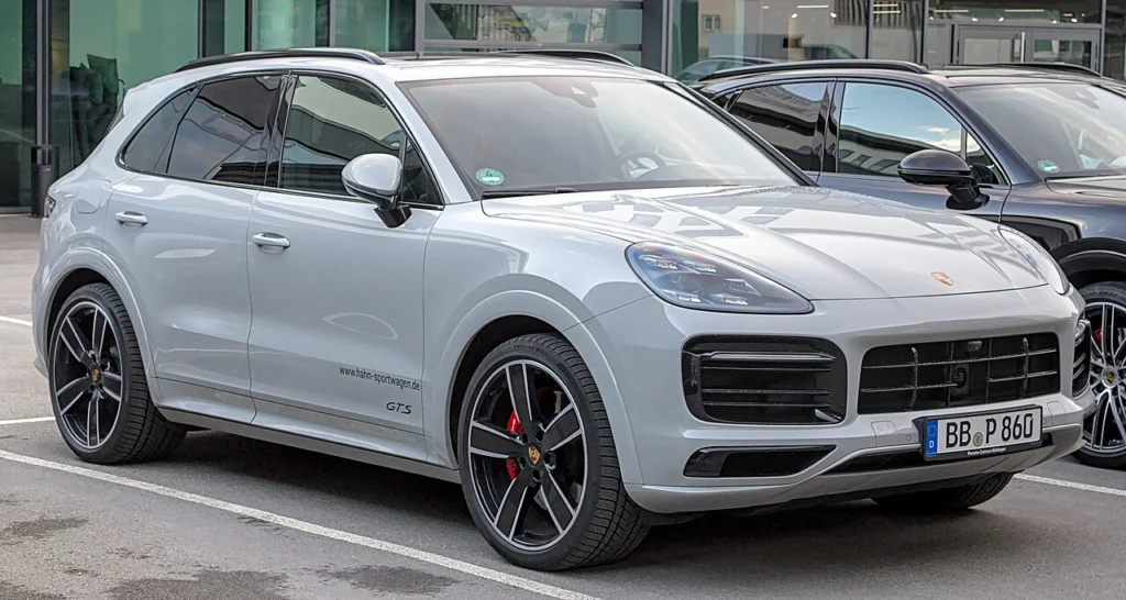 Silver Porsche Cayenne GTS SUV parked outside a showroom