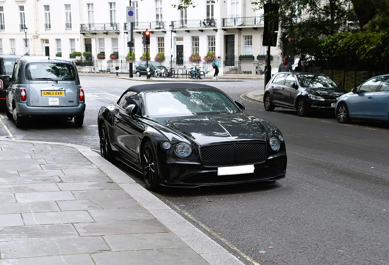 Black Bentley Continental GTC with its roof raised, parked on a street